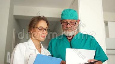 近距离画像两个医生，一个成熟的男人和一个年轻的女人，医生看着框架微笑。 <strong>医务</strong>所职员
